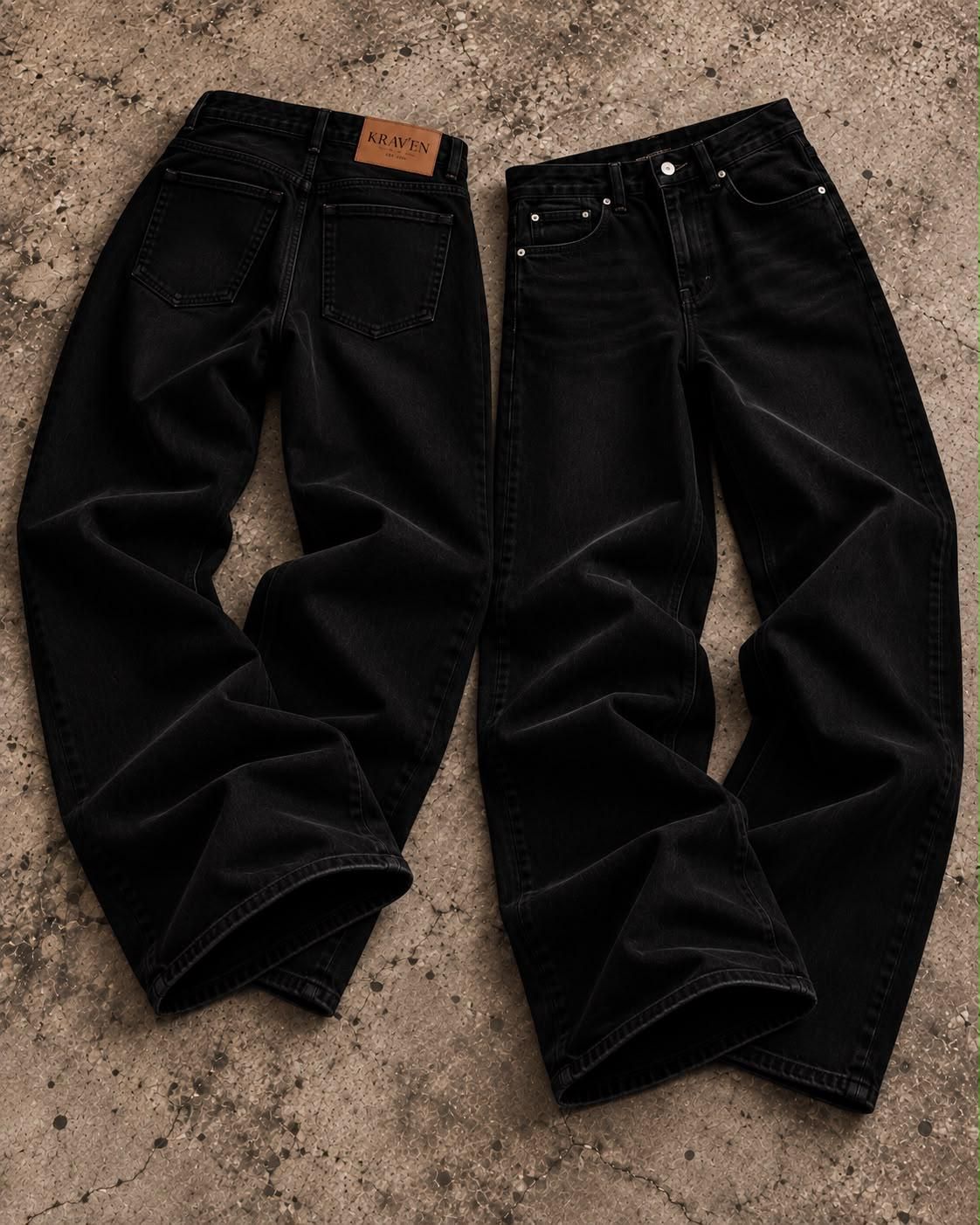Krav'en Wide-Leg Denim in Jet Black, back and front, laid flat on concrete, with the leather Krav'en patch on the back waistband.