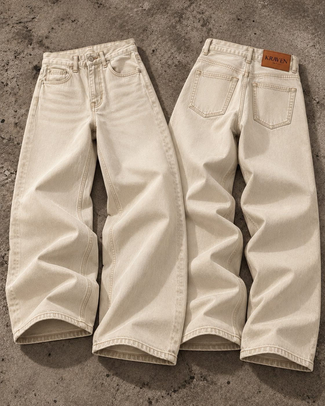 Krav'en Wide-Leg Denim in Ecru, front and back, laid flat on concrete, with the tan leather Krav'en patch on the back waistband.